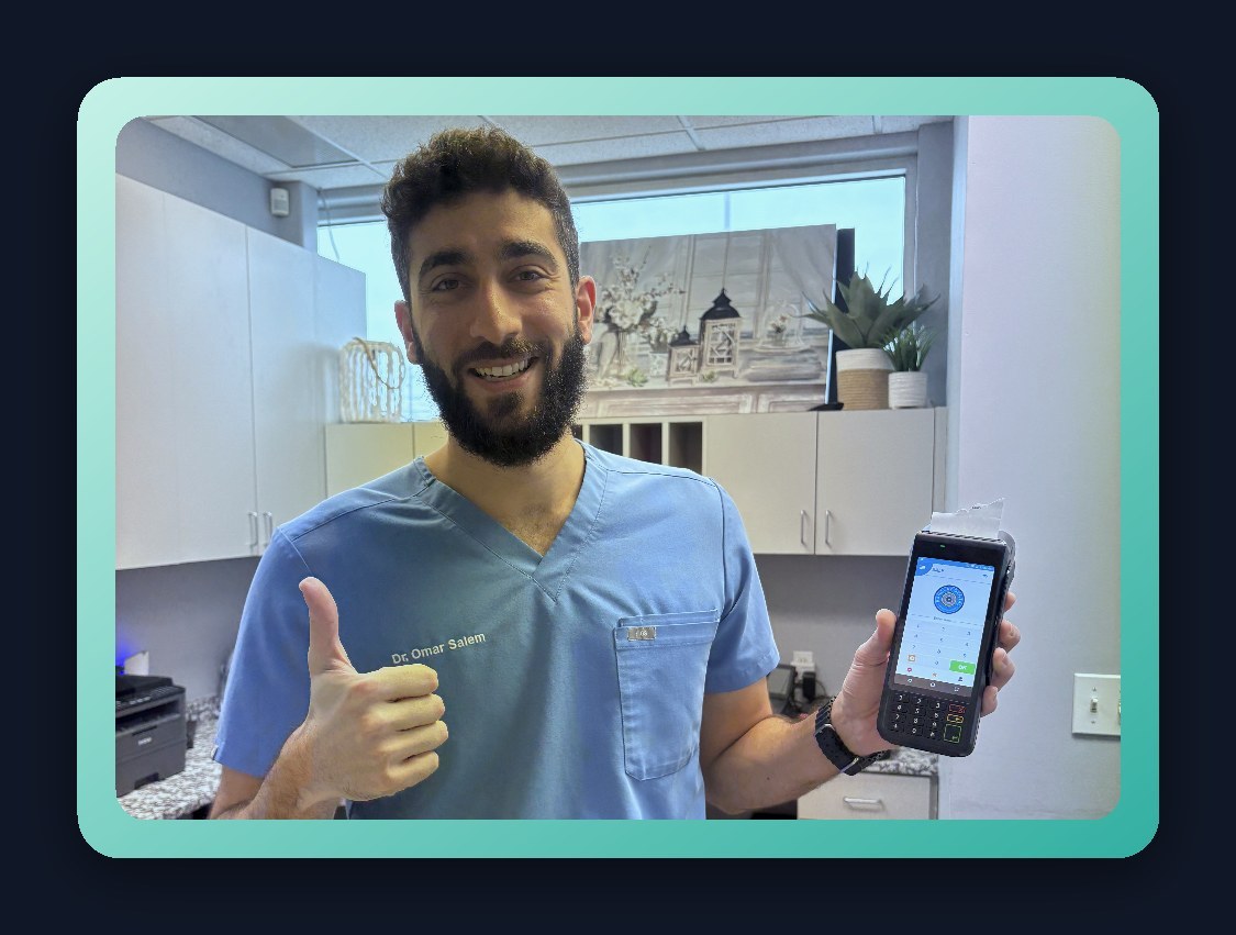 Clinic staff member holding a Swipe Tech wireless terminal